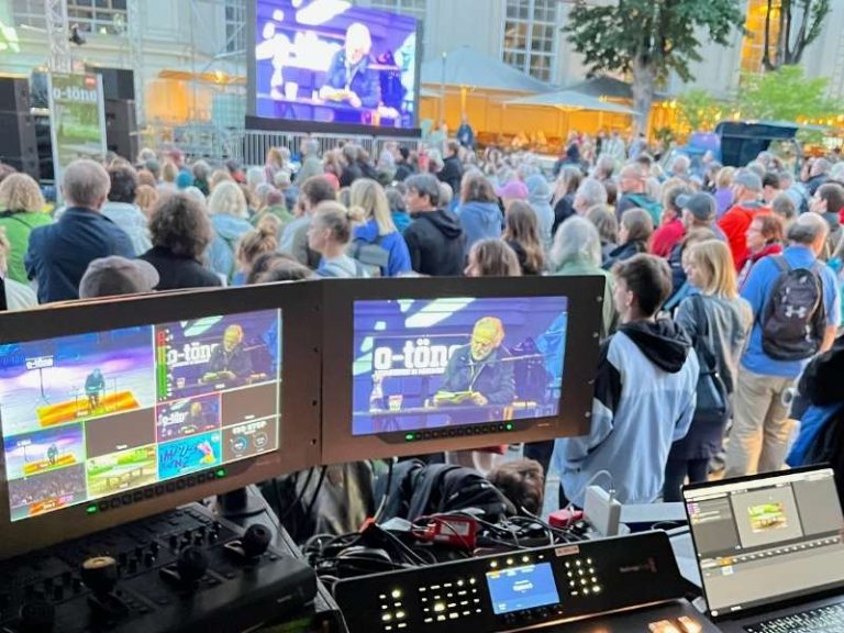 Bildschirme der Eventpower Videotechnik im Vordergrund, dahinter das Publikum des ImPulsTanz Festivals Wien.